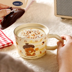 Detail of ceramic bear mug with lid showing the Harvest happiness design and usage scene