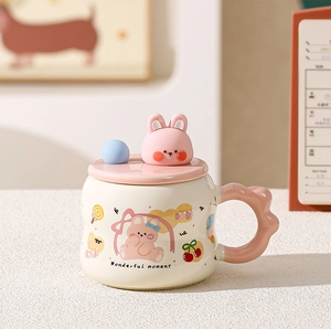 Detail of ceramic mug showing a 3D pink rabbit lid and wavy handle with cute illustrations