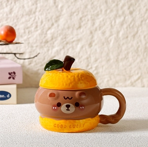 Detail of creative ceramic mug with orange fruit texture and green leaf lid handle