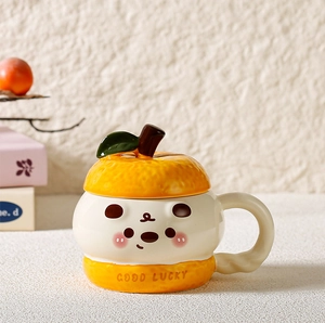 Close-up of ceramic mug featuring cute cartoon face, good lucky text and orange lid