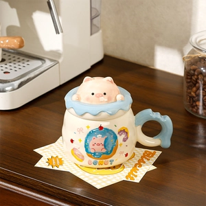 Detail of ceramic mug with 3D pig lid, donut pattern, and light blue handle on warm background