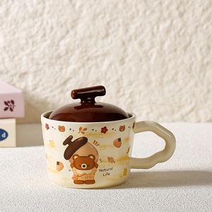 Detail of a ceramic bear mug with unique wavy handle and dark brown lid with twig grip