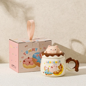 Close-up of ceramic pig mug with 3D doughnut lid and matching pink gift box packaging