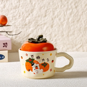 Close-up of ceramic mug with creative persimmon lid and cute cat illustration detail