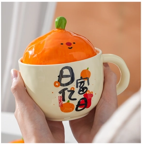 Close-up of ceramic mug with orange lid and fortune calligraphy in hands