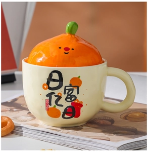 Detail showing high-gloss ceramic mug with orange-shaped lid and festive illustration