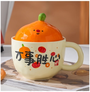 Close-up of ceramic festive mug with orange lid and Chinese calligraphy pattern