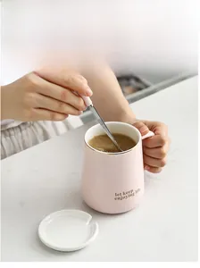 Pink ceramic mug with gold lettering showing coffee stirring detail in natural light