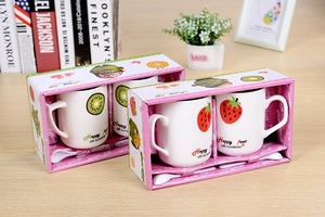Detail of fruit themed ceramic mug gift set featuring strawberry and kiwi patterns