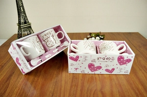 Detail of cute cartoon ceramic mug gift set with matching spoons and pink packaging box