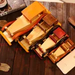 Set detallado de tres portalápices de coche de madera retro en varios tamaños