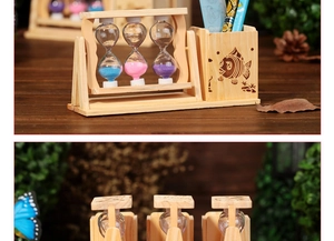 Detalle de un portalápices de madera con reloj de arena de colores y tallado de peces