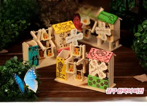 Détail d'une boîte à musique en bois avec figurine d'ours colorée et lettres gravées