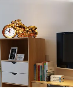 Detailed close-up of a vintage golden motorcycle clock on a wooden shelf with home decor