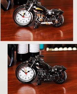 Detail of creative vintage motorcycle clock with gold accents on a wooden desk setup