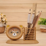 Close-up of bear-shaped wooden pencil holder with built-in analog clock on desk