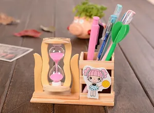 Detail of wooden bear pencil holder with pink hourglass and sand timer on a student desk