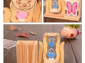 Macro view of wooden pen holder with blue sand hourglass and cartoon bear engraving