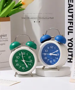 Réveils classiques à double cloche en vert et bleu sur une table blanche décorative