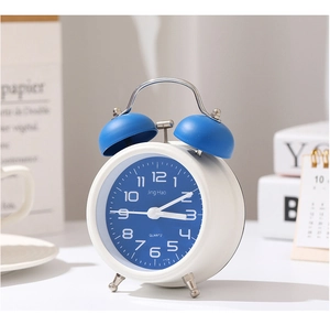 Vue détaillée d'un réveil classique bleu et blanc à double cloche dans un décor doux