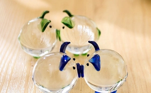 Macro shot of glass pig figurines in clear, green, and blue hand-blown glass