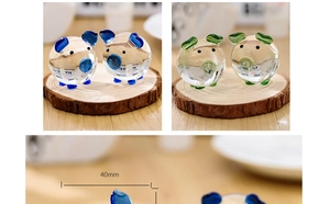 Detail of 40mm crystal pig figurine with blue and green accents on a wooden tray