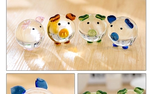 Detailed view of four colorful glass pig figurines on a wooden surface with soft lighting