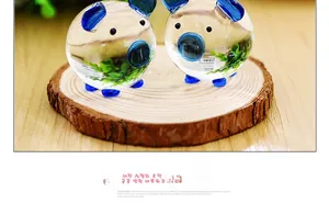 Detail of glass pig figurines with blue accents and green interior moss landscaping