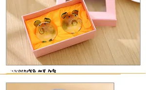 Macro detail of golden crystal pig figurines in a pink gift box with yellow satin