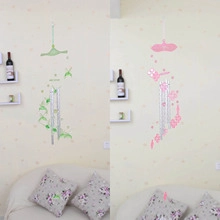 Detail of owl wind chimes set with silver metal tubes and floral decorative wall stickers