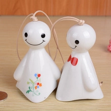 Detail of Teru Teru Bozu ceramic charms with floral patterns and red bow tie details