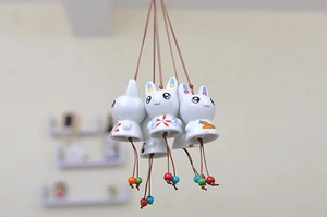 Detail of cute ceramic rabbit wind chime with hand-painted patterns and colorful beads
