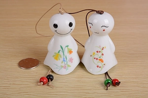 Macro view of ceramic sunny doll wind chimes with floral patterns and wooden beads
