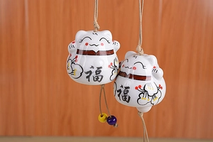 Detailed macro view of ceramic lucky cat wind chime bells with Fook character