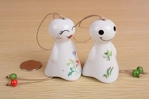 Pair of ceramic wind chimes with hand-painted smiling faces and floral details