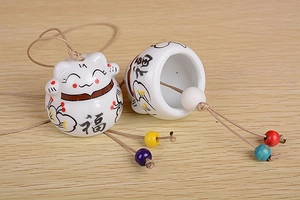 Detail of ceramic lucky cat bell with FUKU calligraphy and colorful decorative beads