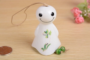 Close-up of a white ceramic wind chime with floral pattern and a cute smiley face detail