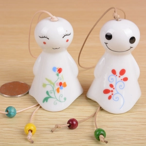 Pair of smiling ceramic doll wind chimes with colorful floral patterns and wooden beads
