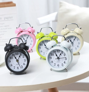 Close-up of colorful twin bell alarm clocks in black, pink, green, blue and cream white