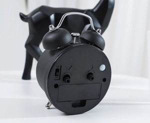 Detail view of the black twin bell alarm clock back with time and alarm control knobs