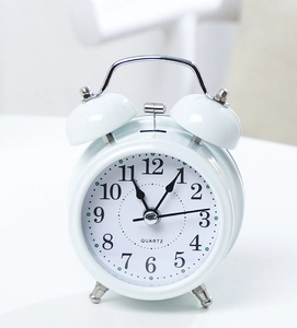 Close-up of white twin bell alarm clock with quartz movement and clear black numerals