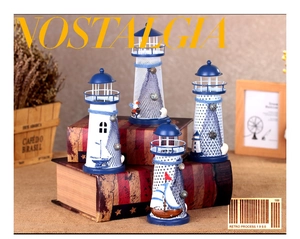 Detail of four Mediterranean tin lighthouses with fishing nets and shells on a book