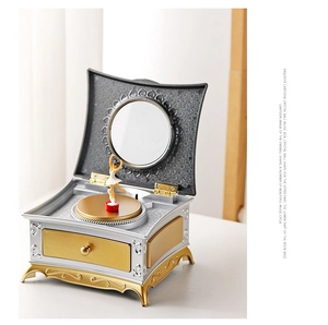 Détail d'une boîte à bijoux musicale vintage avec danseuse, accents dorés et miroir intégré