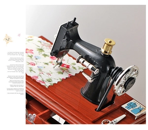 Close-up of vintage sewing machine music box with dark wood base and floral fabric detail