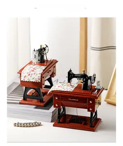 Detailed close-up of vintage sewing machine music box with floral cloth and tiny scissors