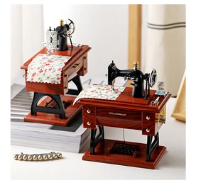 Detailed close-up of a vintage sewing machine music box with floral fabric and small scissors