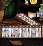 Macro shot of 12 mini glass wishing bottles with cork stoppers and color scrolls in gift box