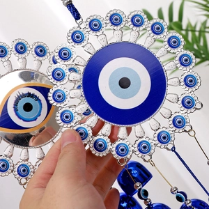 Close-up of Turkish blue evil eye wall hanging with metal petals and dangling blue bells