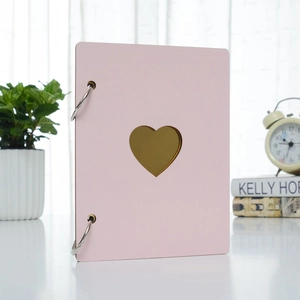 Detail of pink wooden album featuring heart cutout and silver metal ring binder