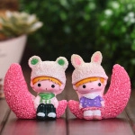 Macro shot of cute cartoon couple sitting on a pink moon base resin micro landscape